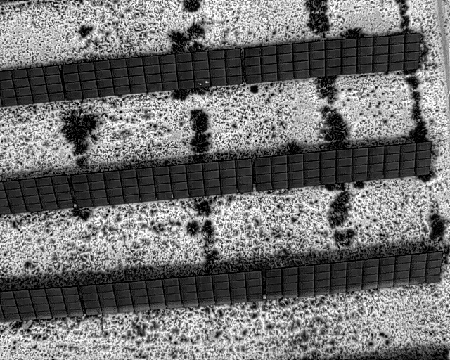 Thermal image of PV panels showing small white spots on individual panels